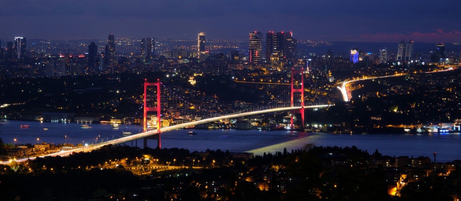 Bosphorus Bridge illuminated at night with the Istanbul skyline